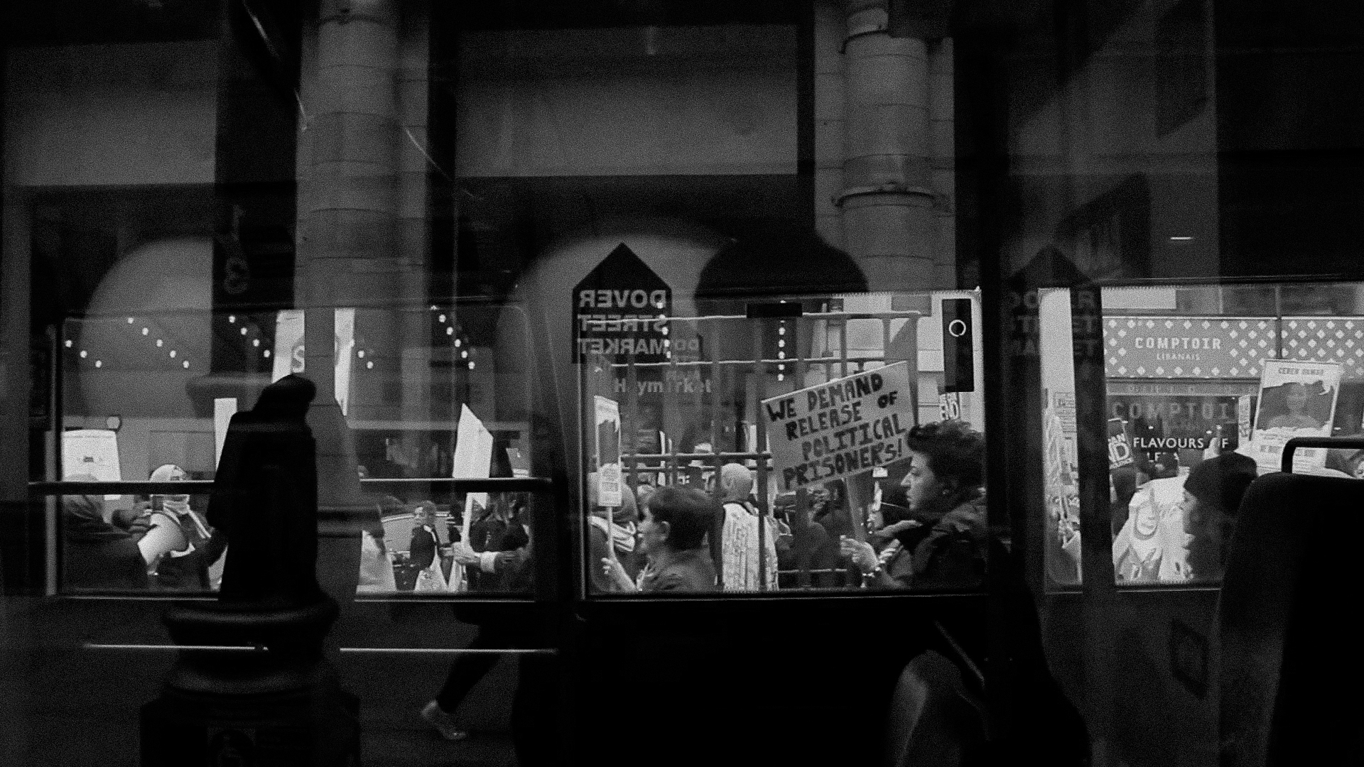 A shot of Protestors marching through glass window.