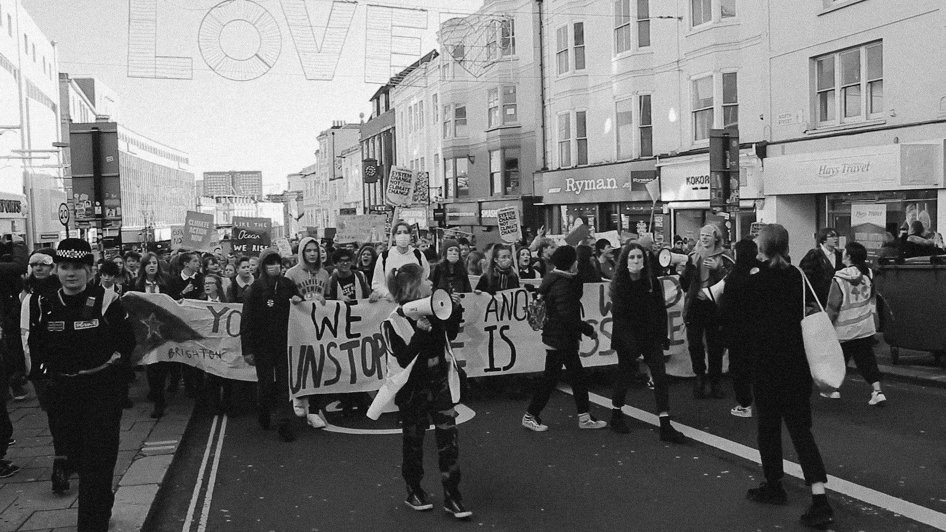 Protestors marching down the road holding signs for climate justice.